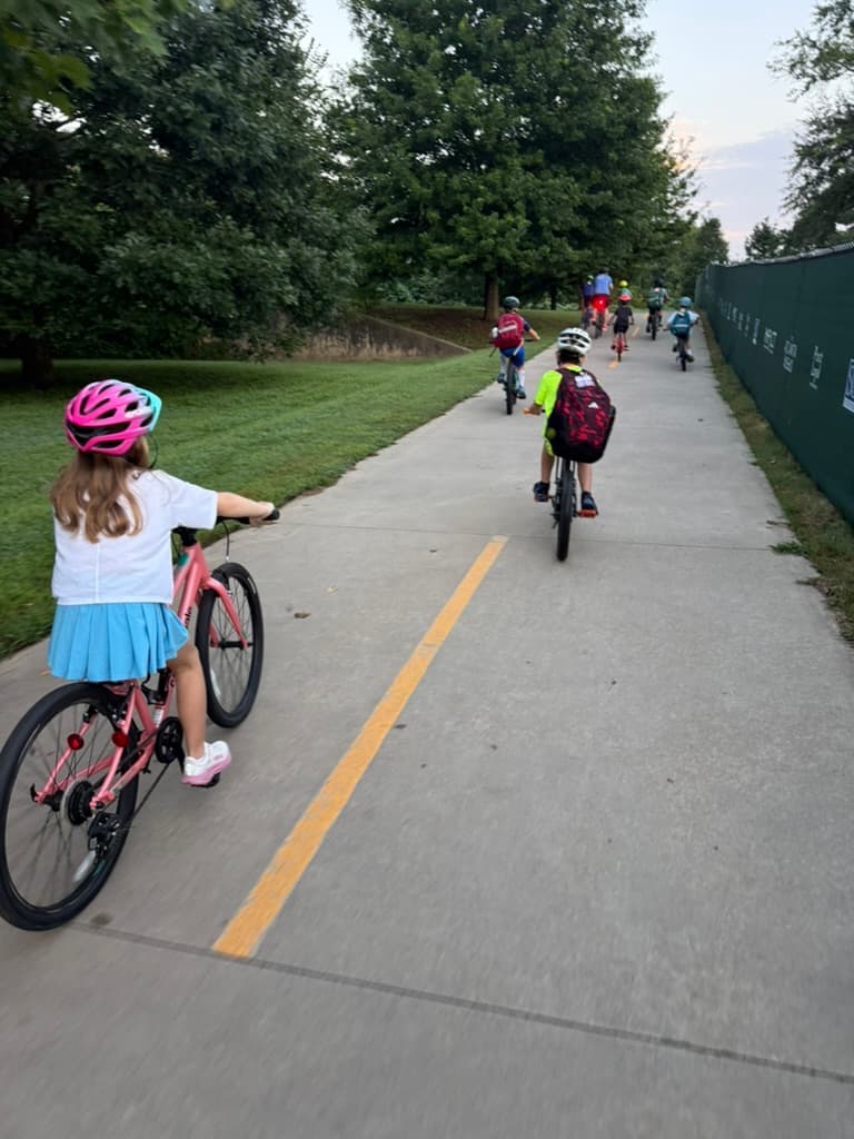 Riders pedaling single file up the trail toward school